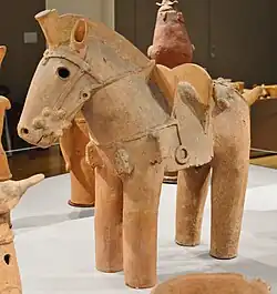 Display of the haniwa horse in the Tokyo National Museum. The haniwa has the shape of a horse with a saddle and bridle.