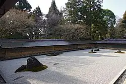 Rock garden with aged clay wall in the background
