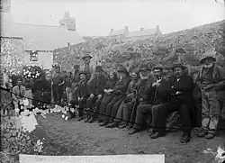 A line of Welsh people sitting outside.