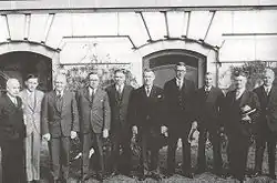 Ten men in 1920s formal dress standing in a row