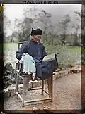An old Confucian scholar reading book in Hanoi, 1915.