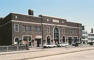 A brick railway station facade on an urban street