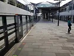 Picture of Bella Vista station. It consists of a platform with platform screen doors within a cutting below ground.
