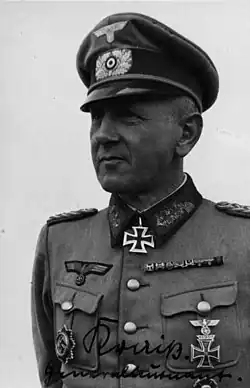 A man wearing a military uniform with an Iron Cross displayed at the front of his uniform collar.
