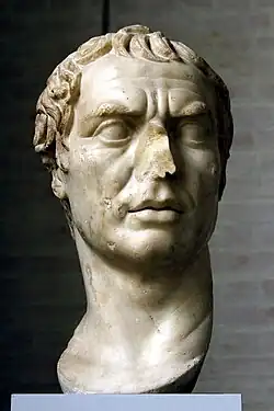 A black and white photograph of a marble bust of a man, with the nose broken off