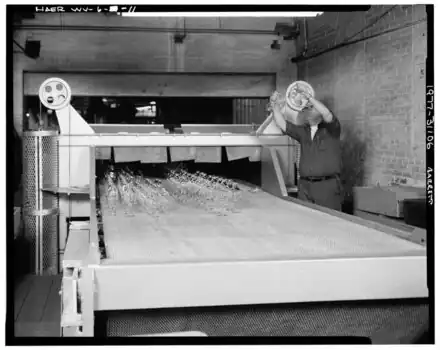 machinery with glassware on it and conveyer to oven