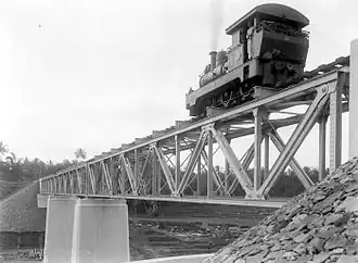 A NIS 254 (now known as DKA C 16 03) steam locomotive runs on a railway bridge of the private-owned Dutch East Indies Railway Company on the line between Secang, Magelang and Parakan, Temanggung, Central Java