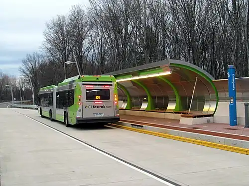A bus at a bus station with a curved canopy