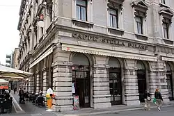'Stella Polare', a café on the corner of an intersection. Tables with umbrellas on one street.