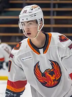 Hockey player skating while wearing a white and orange jersey