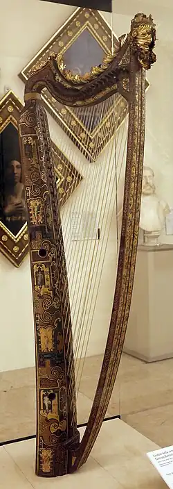 A tall, thin harp with extensive decoration