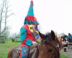 A capuchon wearing Mardi Gras on horseback