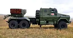 Side profile of an RS‑122, clearly showing its 40-tube launcher and armored KrAZ‑63221 6×6 chassis hull on display.