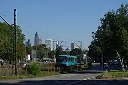 Light rail train running on reserved track in the centre of a dual carriageway road