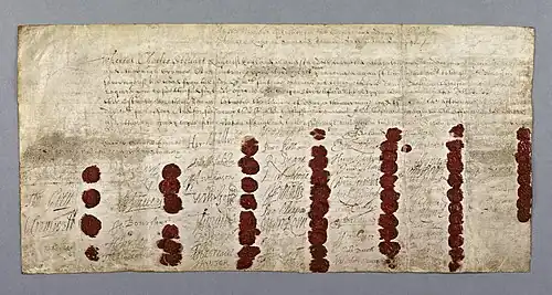 Large hand-written document, coloured yellow with age. There is a block of text at the top, and 59 signatures and red wax seals at the bottom
