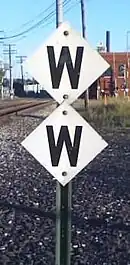 The whistle post sign style of GTW on a double whistle post at Battle Creek, Michigan