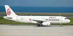 An aircraft painted in white, with a red dragon on its tail and the name Dragonair in both English and Traditional Chinese on the fuselage, taxiing on the taxiway