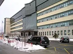 Oblique view of a long, modern building about six storeys high, with many windows and large main entrance