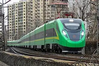 A CR200J is shown in service on a Classic Rail line. The train is lime-green, similar to the colour of trash cans, and has a sleek head.