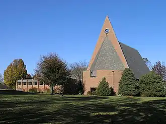 Red brick church with triangular facade and tall, sloping roof