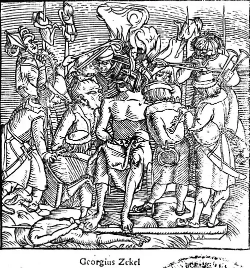 Black-and-white depiction of a man seated on a chair, with a large smouldering crown on his head. He is naked, his crotch covered with a cloth, and his hands are tied behind his hack. Two people are tearing at the flesh of his shoulders with their mouths, ne of them restrained from behind. A man is playing a pipe. The scene is crowded and set in no particular background. At least four people are seen impaled around.