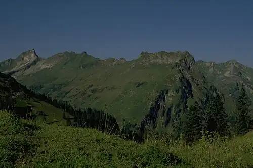 The Giebel (above the left of the three firs, far right) from the Roßkopf. The prominent pinnacle to the left on the arête is the Berggächtle. On the far left is the Schneck.
