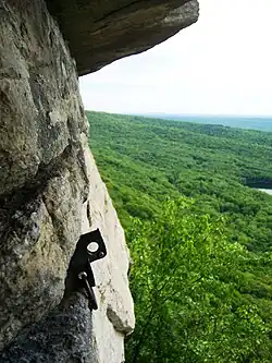 Image of a metal piton that has been hammered into a natural rock face