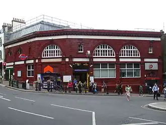 Terracotta railway station building at the bottom of a hill