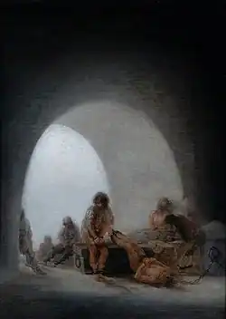 A group of people chained inside a prison.
