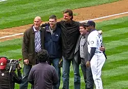 Randy Johnson in a black suit. To his left is Jay Buhner and Dan Wilson. To his right is Edgar Martínez and Ken Griffey Jr.