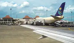 On the apron, Saudi Airlines Boeing 747-300 refueling and reloading to serve Indonesian Hajj pilgrims to Mecca