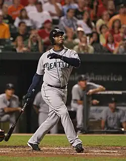 Ken Griffey Jr. batting as a Seattle Mariner. In the background is the Mariner's dugout.