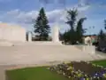 Flower bed and steps in front of the memorial, with two of the four pillars.