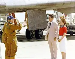 Mattingly (foreground) with Henry Hartsfield salutes President Ronald Reagan, next to First Lady Nancy Reagan, after the STS-4 landing on July&nbsp;4, 1982