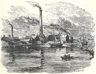 factory near water with smokestacks