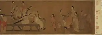A long, horizontally oriented painting depicting fifteen people in a room. All but two of the people are adult men who are busy reading.