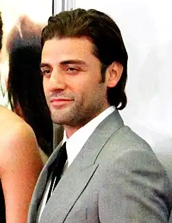 Oscar Isaac smiling to his left