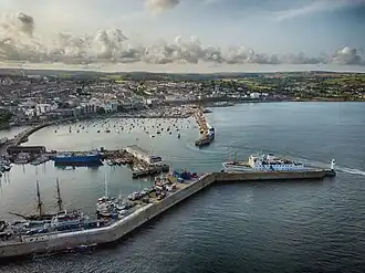 Pier with lighthouse at the end, and boat docked on left hand side