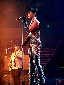 A young woman performing on a microphone while wearing a see-through outfit