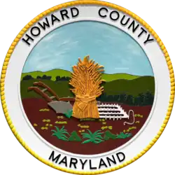 A round seal featuring a sheaf of grain in a field with a white border
