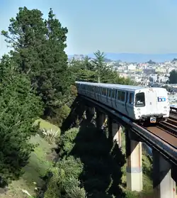 A southbound BART train passes San Francisco's Outer Mission neighborhood, between the Balboa Park station and the Daly City station.