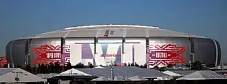 photo of State Farm Stadium taken from the parking lot, showing the domed stadium against an overcast sky