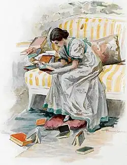 A girl in a gray satin dress sits on the edge of a sofa with large orange and white stripes, her body leaning forward, her naked forearms resting on her thighs. She reads a book she holds in her hands. Around her other books are scattered.