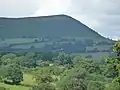 In the distance, A barren mountain ridge top viewed from the east. The ridge falls away to the north.
