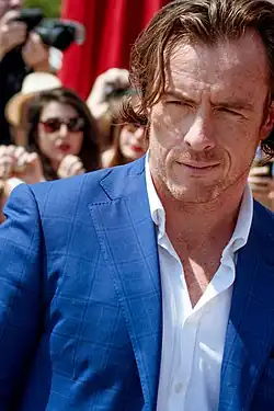 Toby Stephens in a blue jacket