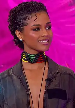 Tyla with curly hair and pink background during the Jennifer Hudson Show.