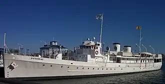 Photograph of the Presidential yacht USS Potomac at dock on a sunny, clear day.