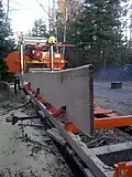 A white pine flitch dogged onto a portable sawmill, ready to be cut into a finished board.