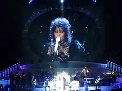 A woman singing onstage with a microphone
